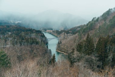 Panoramic View of Japan local train with Tadami river and bridge. Tadami Railway Line in The Valley at Mishima Machi, Aizu, Fukushima Prefecture, Japan. Landmark and iconic spot for tourist attraction clipart