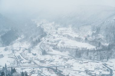 view of village with snow in winter from mountain viewpoint of Yamadera temple, the popular name for the Buddhist temple of Risshakuji located in Yamagata City, in Yamagata Prefecture, Tohuku, Japan clipart