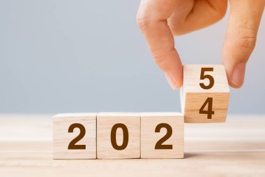 2024 'ten 2025' e kadar olan el çevirme bloğu masada. Çözüm, gözden geçirme, strateji, yıl sonu, hedef, iş ve yeni yıl tatil kavramları
