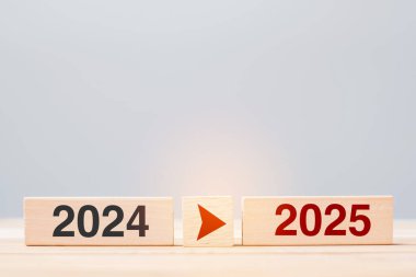 2025 ve 2024 tahta blok masa arkasında. Çözüm, strateji, geri sayım, hedef, değişim ve yeni yıl tatili kavramları