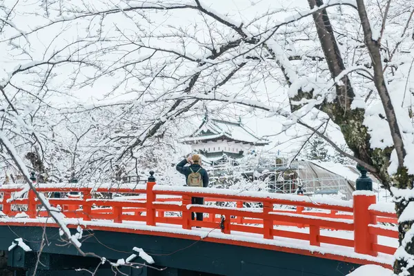 stock image Woman tourist sightseeing Hirosaki Castle in winter, happy traveler travel Hirosaki city, Aomori Prefecture, Tohoku, Japan. Landmark and famous for tourist attraction. Japan travel and vacation