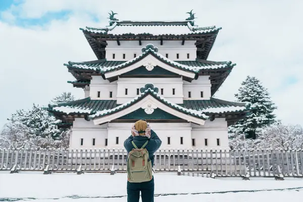 stock image Woman tourist sightseeing Hirosaki Castle in winter, happy traveler travel Hirosaki city, Aomori Prefecture, Tohoku, Japan. Landmark and famous for tourist attraction. Japan travel and vacation