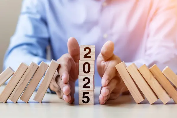 stock image Businessman hand Stopping Falling of 2025 wooden Blocks. Business, Risk Management, Insurance, Resolution, strategy, solution, goal, New Year New You and happy holiday concepts