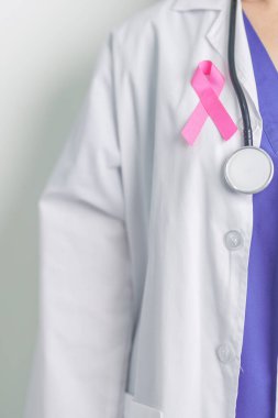 Pembe Ekim Göğüs Kanseri Bilinci Ayı, Pembe Kurdeleli kadın doktor, insanların hayatını ve hastalıklarını desteklemek için hastanede. Ulusal Kanserden kurtulanlar ayı, Anne ve Dünya Kanser Günü konsepti