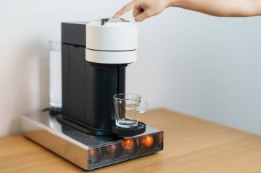 Kahve makinesinden Espresso Kahvesi ve ahşap masa çubuğunda kavrulmuş kahve çekirdeği. Ev, Apartman ve Ofis 'te günlük içecek konsepti