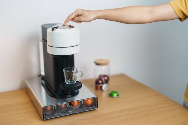 Kahve makinesinden Espresso Kahvesi ve ahşap masa çubuğunda kavrulmuş kahve çekirdeği. Ev, Apartman ve Ofis 'te günlük içecek konsepti