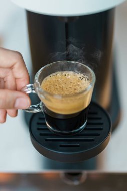 Kahve makinesinden Espresso Kahvesi ve ahşap masa çubuğunda kavrulmuş kahve çekirdeği. Ev, Apartman ve Ofis 'te günlük içecek konsepti