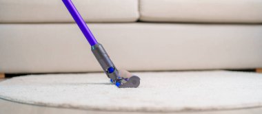 Halıyı kablosuz elektrik süpürgesiyle temizleyen kadın. Ev hanımı kablosuz süpürgeyi evi temizlemek için kullanıyor. Ev işleri, Temizlik, Temizlik, Temizlik, Toz, Temizlik ve günlük rutin