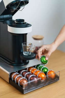 Kahve makinesinden Espresso Kahvesi ve ahşap masa çubuğunda kavrulmuş kahve çekirdeği. Ev, Apartman ve Ofis 'te günlük içecek konsepti