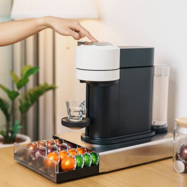 Kahve makinesinden Espresso Kahvesi ve ahşap masa çubuğunda kavrulmuş kahve çekirdeği. Ev, Apartman ve Ofis 'te günlük içecek konsepti