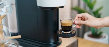 Kahve makinesinden Espresso Kahvesi ve ahşap masa çubuğunda kavrulmuş kahve çekirdeği. Ev, Apartman ve Ofis 'te günlük içecek konsepti