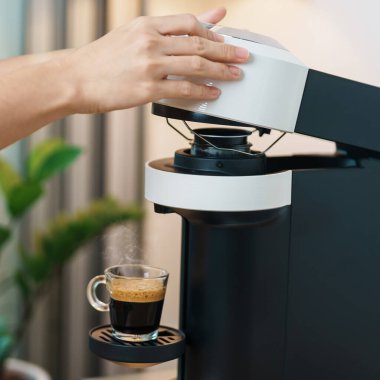 Kahve makinesinden Espresso Kahvesi ve ahşap masa çubuğunda kavrulmuş kahve çekirdeği. Ev, Apartman ve Ofis 'te günlük içecek konsepti