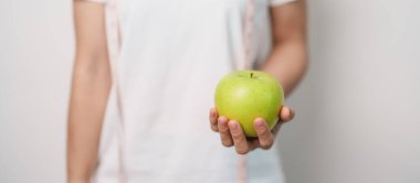 Kadın el ele tutuşan yeşil elma, mutlu kadın spor salonu meyve seçmek sağlıklı yemektir. Diyet kontrolü, kilo kaybı, obezite, yeme tarzı ve beslenme kavramları