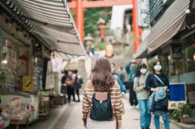 Enoshima Adası, Fujisawa, Kanagawa, Japonya 'da kadın turist ziyareti. Gezginler Enoshima Tapınağı 'nı gezerken mutlu. Tokyo yakınlarındaki turistler için önemli ve popüler bir yer. Seyahat ve Tatil kavramı