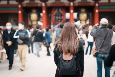 Sensoji Tapınağı 'nı ziyaret eden turist bir kadın veya Asakusa Kannon Tapınağı, Tokyo, Asakusa' da bulunan bir Budist tapınağıdır. Kırmızı fenerde Japonca cümle Şimşek kapısı anlamına gelir.