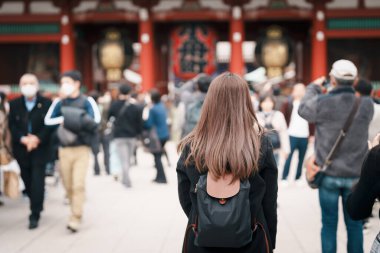 Tourist woman visit Sensoji Temple or Asakusa Kannon Temple is a Buddhist temple located in Asakusa, Tokyo Japan. Japanese sentence on red lantern means Thunder gate. clipart