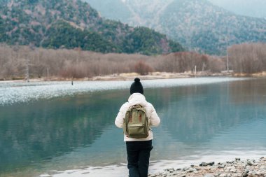 Kadın turist Kamikochi Ulusal Parkı 'nı geziyor, mutlu gezginler dağlı Taisho göleti geziyor, Nagano Bölgesi, Japonya. Turistler için dönüm noktası. Japonya Seyahat, Varış ve Tatil