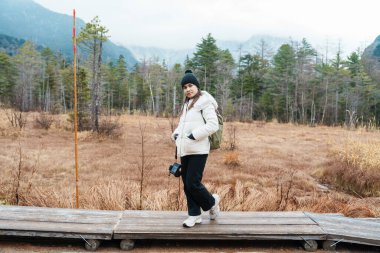 Kadın turist Kamikochi Ulusal Parkı 'nı geziyor, mutlu gezginler dağlı çayır arazilerini geziyor, Nagano Bölgesi, Japonya. Turistler için dönüm noktası. Japonya Seyahat, Varış ve Tatil