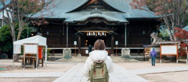 Japonya 'nın Nagano bölgesindeki Matsumoto şehrinde, Nawate Caddesi yakınlarındaki Yohashira Tapınağı' nı gezen kadın turistler. Turistlerin ilgi odağı. Japonya Seyahati