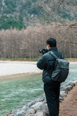 Erkek turist Kamikochi Ulusal Parkı 'na seyahat eder, mutlu gezginler Azusa Nehri' ni dağ, Nagano Bölgesi, Japonya ile gezer. Turistler için dönüm noktası. Japonya Seyahat, Varış ve Tatil