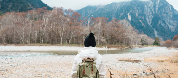 Woman tourist travel Kamikochi National Park, happy Traveler sightseeing Azusa river with mountain, Nagano Prefecture, Japan. Landmark for tourists attraction. Japan Travel, Destination and Vacation