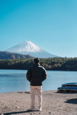 Erkek turist Saiko Gölü 'nde Fuji Dağı' nın keyfini çıkarıyor, mutlu gezgin Fuji Dağı 'nı geziyor ve Fuji 5 Gölü' nü geziyor. Turistler için dönüm noktası. Japonya Seyahat, Varış ve Tatil