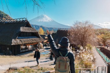 Woman tourist with mount Fuji at Saiko Iyashino Sato Nenba in Autumn season, happy Traveler travel Mt Fuji, Yamanashi, Japan. Landmark for tourist attraction. Japan Travel, Destination and Vacation clipart