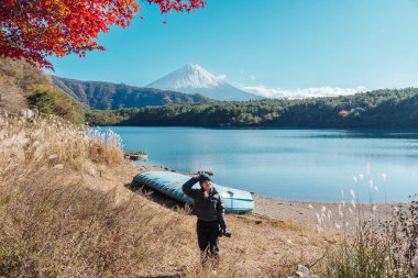 Fuji Dağı ile sonbahar mevsiminde Saiko Gölü 'nde bir kadın turist, mutlu gezgin Fuji Dağı, Yamanashi, Japonya' da seyahat ediyor. Turistler için dönüm noktası. Japonya Seyahat, Varış ve Tatil