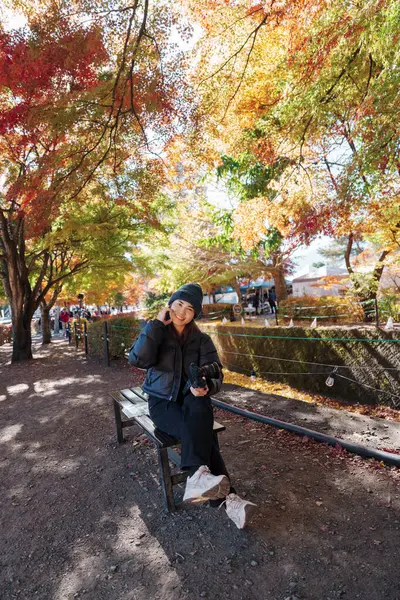 Sonbahar sezonunda Momiji Kairo 'da kadın turist, mutlu gezgin Kawaguchi Gölü, Yamanashi, Japonya' da Maple Koridoru 'nda seyahat ediyor. Turistler için dönüm noktası. Japonya Seyahat, Varış ve Tatil