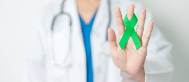 Dünya Lenfoma Bilinci Eylül ayı için yeşil kurdeleli doktor, Akıl Sağlığı Günü, Karaciğer, Safra kesesi, safra kanalı, rahim ağzı, böbrek kanseri. Sağlık ve dünya kanser günü konsepti