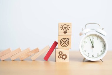 Ahşap blok saat ile iş simgesine düşüyor. Beyin fırtınası, hedef, hedef, takım çalışması ve strateji. risk yönetimi, mali, deflasyon ve enflasyon, sigorta ve ekonomik durgunluk