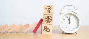 Ahşap blok saat ile iş simgesine düşüyor. Beyin fırtınası, hedef, hedef, takım çalışması ve strateji. risk yönetimi, mali, deflasyon ve enflasyon, sigorta ve ekonomik durgunluk