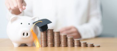 Eğitim, burs, öğrenci kredisi ve borç için para biriktirme ve gelecek planı eğitimi. Domuzcuk ve mezuniyet şapkasıyla büyüyen madeni paralar.