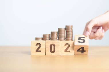 2024 'ün sonundaki mutlu yıllar 2025' e madeni paralarla. Para, Bütçe, vergi, yatırım, finans, tasarruf ve Yeni Yıl Çözüm kavramları