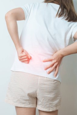 Evde sırt ağrısı çeken bir kadın. Piriforis Sendromu, bel ağrısı ve omurga baskısı nedeniyle kas ağrısı olan yetişkin bir kadın. Ofis sendromu ve tıbbi konsept