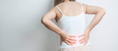 Evde sırt ağrısı çeken bir kadın. Piriforis Sendromu, bel ağrısı ve omurga baskısı nedeniyle kas ağrısı olan yetişkin bir kadın. Ofis sendromu ve tıbbi konsept