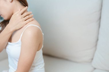 Evde Neck ve Omuz ağrısı çeken bir kadın. Miyofasyal ağrı sendromu, fibromiyalji, romatizma, skapüler ağrı, boyun omurgası. ergonomik kavram