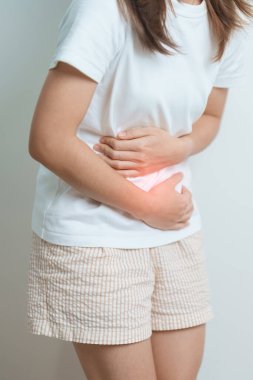 Karın ağrısı, kabız olmuş sindirim ya da gıda zehirlenmesi, kadın sorunu ve endometriyozis, histerektomi ve regl nedeniyle karın ağrısı çeken bir kadın. 