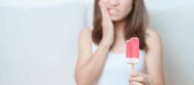 Dişler Soğuğa Duyarlı konsepti. Kadın dondurma tutuyor ve yedikten sonra diş ağrısı çekiyor. Diş çürüğü veya Sakız Hastalığı, Öğütücü Diş ve Stres, Korunmasız Sinir Kökleri, Çatlak ve Alınan Dişetleri