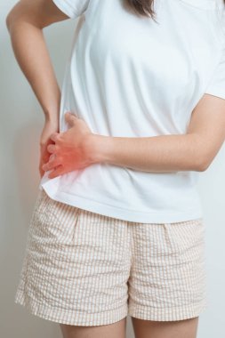 Evde sırt ağrısı çeken bir kadın. Piriforis Sendromu, bel ağrısı ve omurga baskısı nedeniyle kas ağrısı olan yetişkin bir kadın. Ofis sendromu ve tıbbi konsept