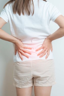 Evde sırt ağrısı çeken bir kadın. Piriforis Sendromu, bel ağrısı ve omurga baskısı nedeniyle kas ağrısı olan yetişkin bir kadın. Ofis sendromu ve tıbbi konsept