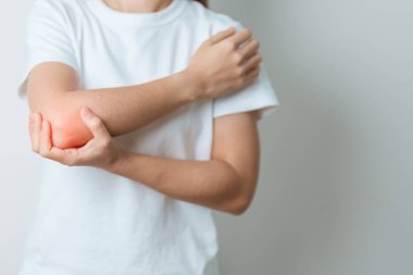 Kadının evinde dirsek ağrısı, yan epikondilit ya da tenis dirseği yüzünden kas ağrısı var. yaralanma, sağlık ve tıbbi konsept