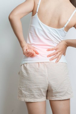 Evde sırt ağrısı çeken bir kadın. Piriforis Sendromu, bel ağrısı ve omurga baskısı nedeniyle kas ağrısı olan yetişkin bir kadın. Ofis sendromu ve tıbbi konsept