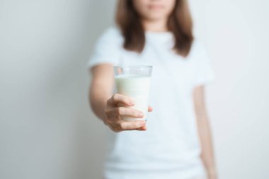 Süt içeceği ve günlük rutin konsepti. Genç bir kadın evde yüksek kalsiyum ve beslenme ile süt içiyor, kadın bardakta protein ile soya sütü tutuyor. Sağlıklı, sağlıklı ve mutlu bir yaşam tarzı.