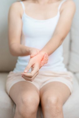 Evde bileği ağrıyan bir kadın, De Quervain 's tenosynovitis, ergonomic, Carpal Tunnel Sendromu veya Office sendromu ve Parkinson hastalığı konsepti nedeniyle kas ağrısı çeken bir kadın.