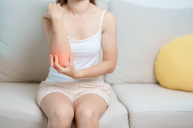 Kadının evinde dirsek ağrısı, yan epikondilit ya da tenis dirseği yüzünden kas ağrısı var. yaralanma, sağlık ve tıbbi konsept