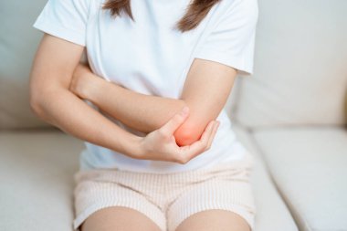 Kadının evinde dirsek ağrısı, yan epikondilit ya da tenis dirseği yüzünden kas ağrısı var. yaralanma, sağlık ve tıbbi konsept