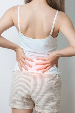 Evde sırt ağrısı çeken bir kadın. Piriforis Sendromu, bel ağrısı ve omurga baskısı nedeniyle kas ağrısı olan yetişkin bir kadın. Ofis sendromu ve tıbbi konsept
