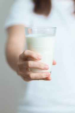 Süt içeceği ve günlük rutin konsepti. Genç bir kadın evde yüksek kalsiyum ve beslenme ile süt içiyor, kadın bardakta protein ile soya sütü tutuyor. Sağlıklı, sağlıklı ve mutlu bir yaşam tarzı.