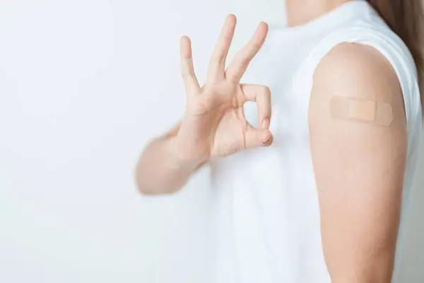 stock image Woman with bandage after receiving vaccine. Vaccination and Immunization for Influenza, HPV, Zoster, IPD, DTP or Diphtheria, Tetanus and Pertussis, MMR, Hepatitis B, Covid  and Varicella vaccine